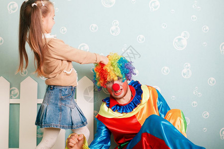 小女孩拉着小丑的头发图片