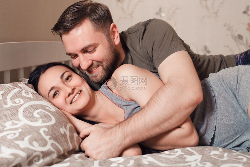 在床上拥抱的一对夫妇图片