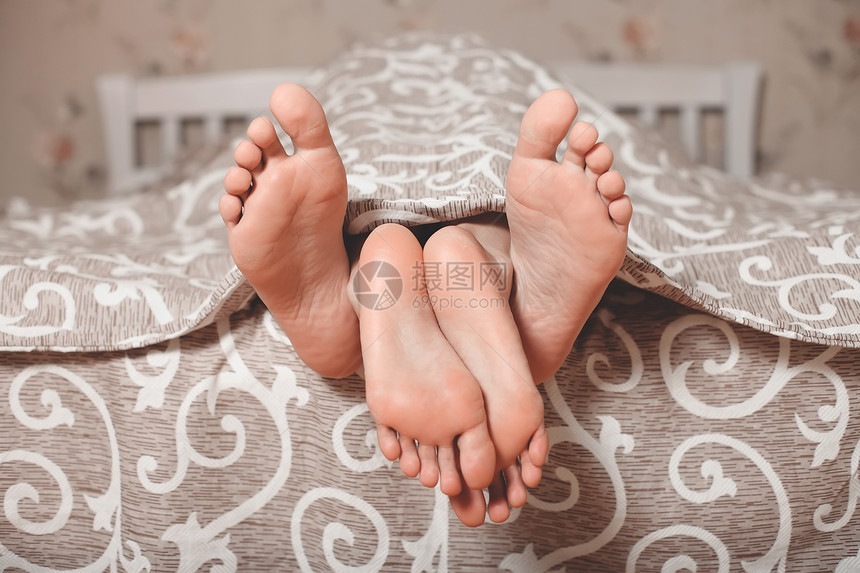 情侣的双脚从毯子伸出图片
