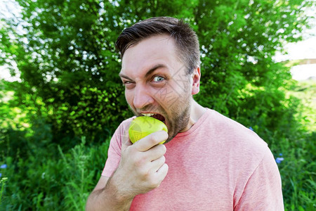 男人在户外吃苹果图片