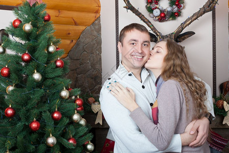 情侣在圣诞树旁亲吻图片