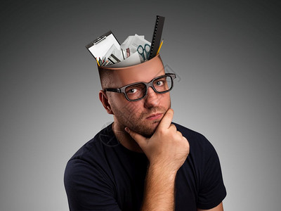 一个头上挂着办公设备的人在沉思图片