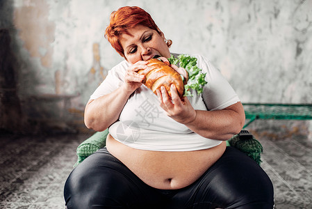 胖女人坐在椅子上吃三明治图片
