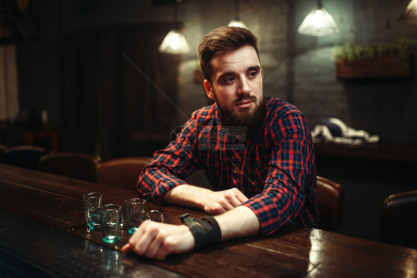 男人坐在吧台酗酒图片
