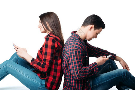 双人背靠坐在一起使用手机白色背景意识操纵概念图片