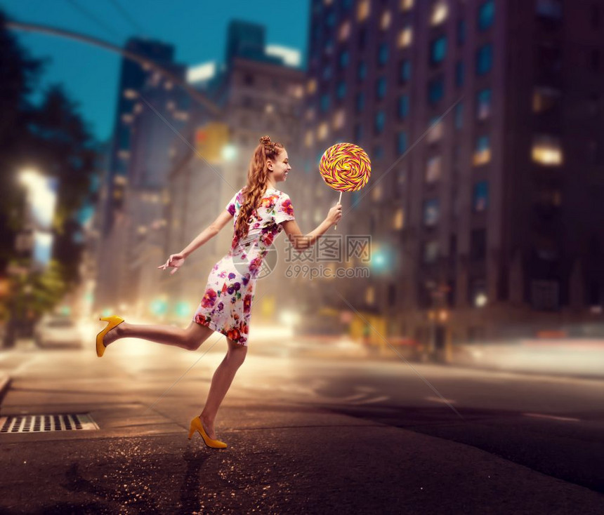 时髦的金色卷发女孩穿着多彩的夏天裙子夜市背景的时髦女孩图片