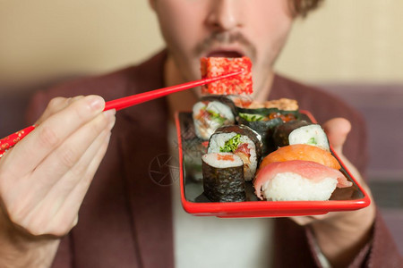手握着筷子在吃寿司卷图片