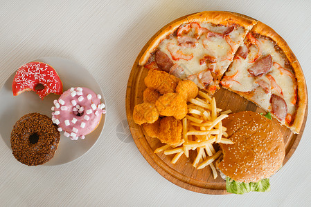 高卡路里不健康食物汉堡薯条和甜甜圈图片