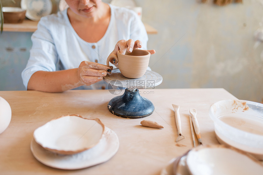 女陶瓷罐车间妇女制作碗手工陶瓷艺品用粘土制作的餐具女陶瓷炉车间图片