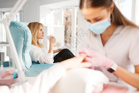 美容师为女顾客做指甲护理治疗图片
