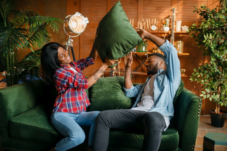 黑人情侣在沙发上玩枕头搏斗游戏图片