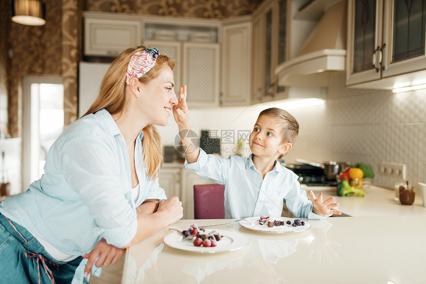 可爱的女人和小男孩在厨房做甜点图片