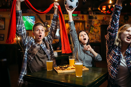 年轻朋友在酒吧庆祝比赛胜利图片