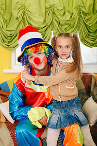 女孩小丑小女孩拥抱一个快乐的小丑背景