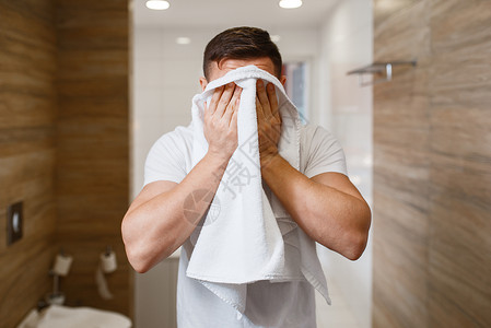 男人在浴室用毛巾擦脸图片