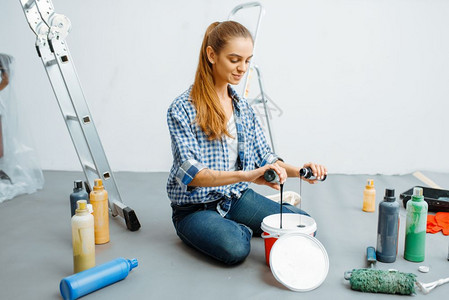女油漆工在搅拌油漆背景图片