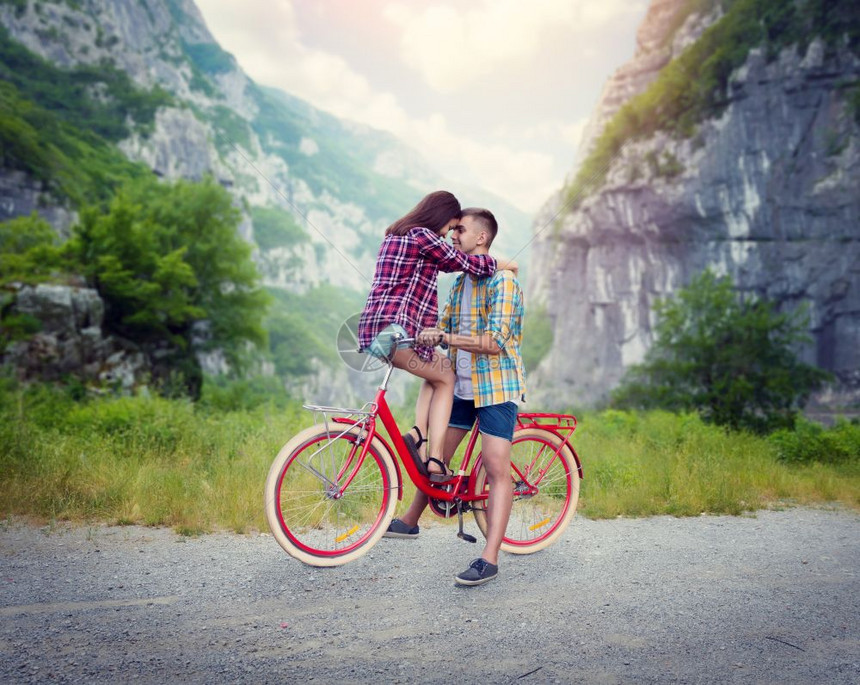 年轻男女一起在自行车上拥抱图片