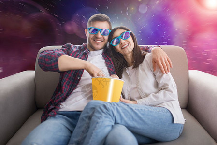 男子陪女朋友带着眼镜吃着米花在看电影图片