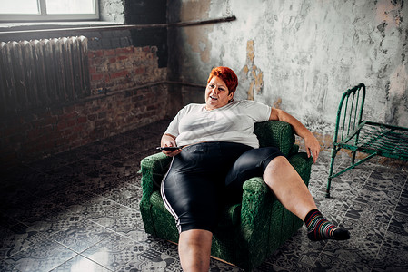 超重妇女坐在椅子上看电视不健康的生活方式肥胖症图片
