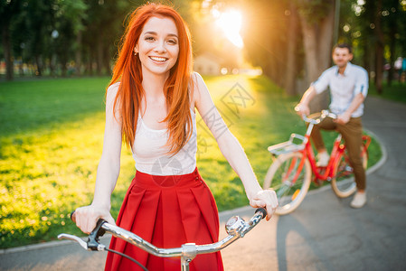 快乐的情侣在公园骑着自行车背景图片