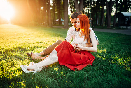 情侣坐在公园草地上约会图片