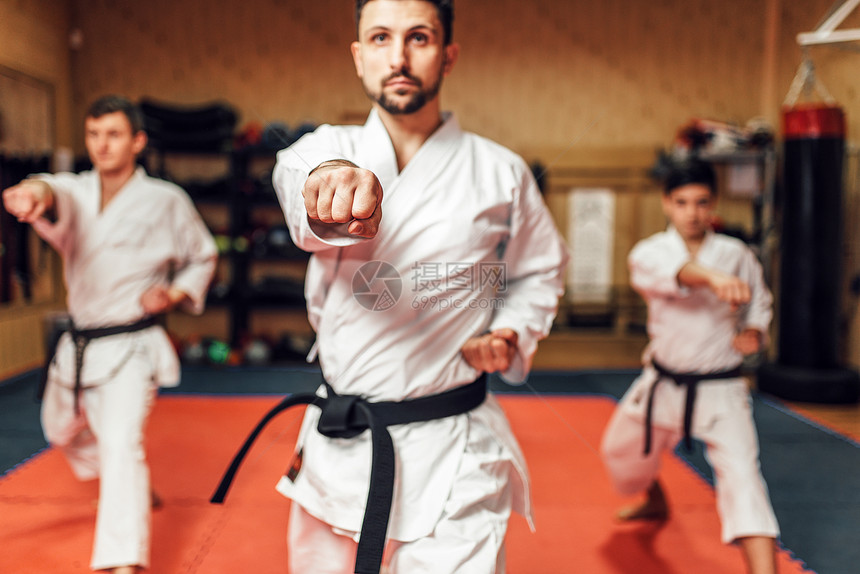 空手道拳大师及其门徒在白色和服黑带中磨练他们的技能作战训练健身锻炼图片
