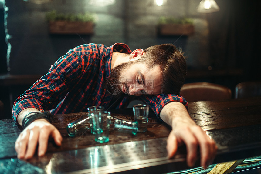 男人睡在酒吧柜台上图片