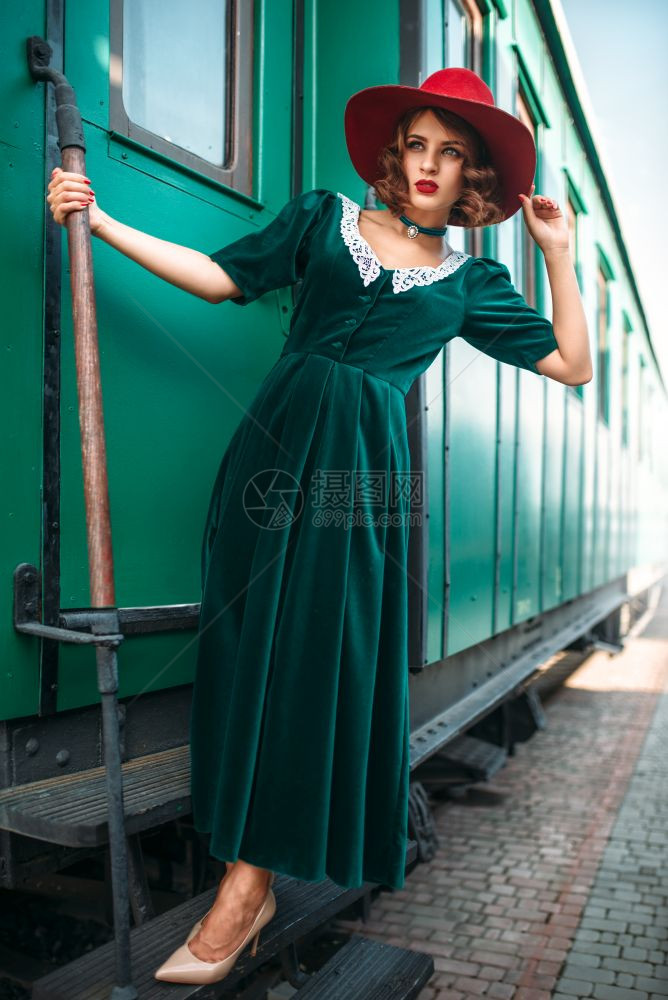 红色戴帽子的女与旧火车铁路旅行图片