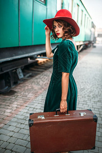 古老的女人乘坐古的火车旧站道年轻的老女人乘坐古的火车图片