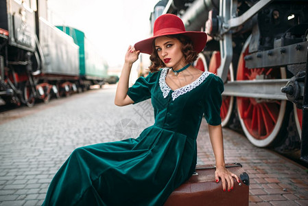 戴着红色帽子的女子与古老蒸汽火车合影图片