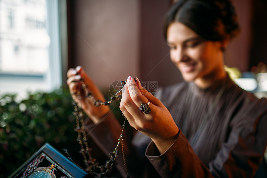 典雅的门店里女人看着项链盒图片