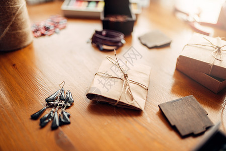 木制桌上的礼品盒和手工制作的耳环缝纫配件手工制作的首饰双约耳环图片