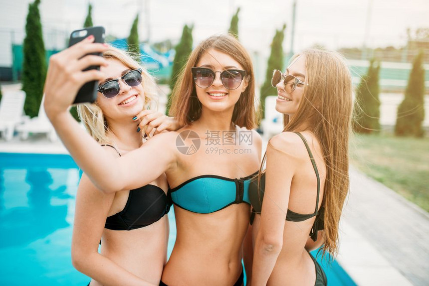 三个女人在泳池边庆祝拍照图片