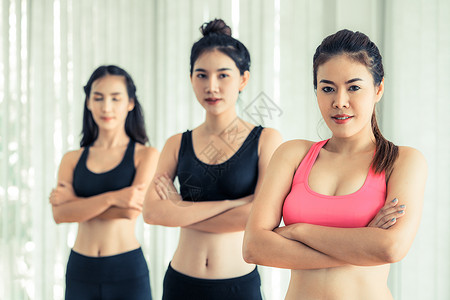 运动妇女团队站在健身房充满信心地跨过双臂健康的生活方式和健康概念图片