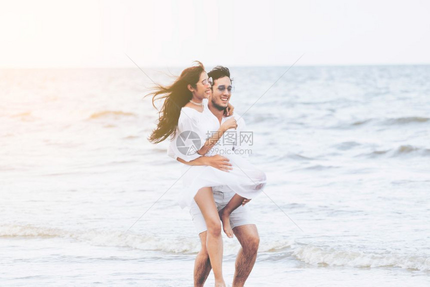 男友抱着女友在沙滩上约会图片