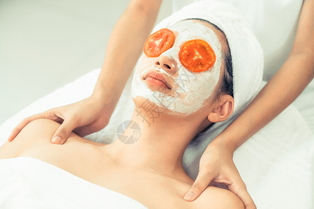 享受番茄奶油面膜面部皮肤护理的美女图片