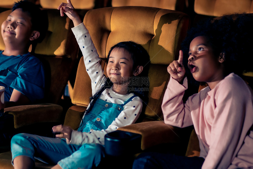 三个孩子玩得开心在电影院看电影图片