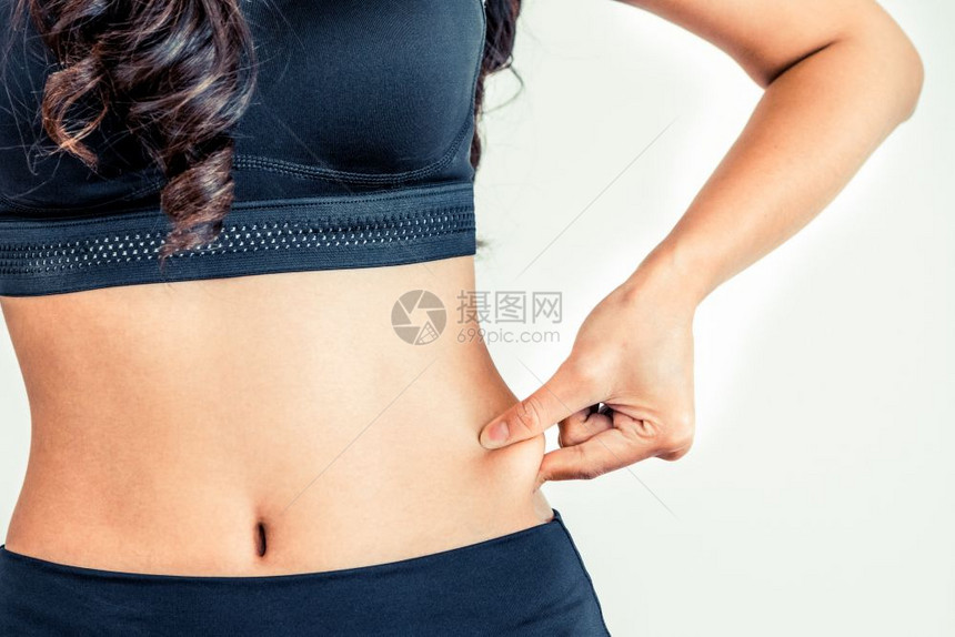 身穿运动服的年轻女子触摸她的肚饮食和减肥概念身穿运动服的年轻女子触摸她的肚图片