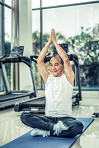 老年男子在健身房练习瑜伽成熟健康的生活方式老年男子在健身房练瑜伽图片