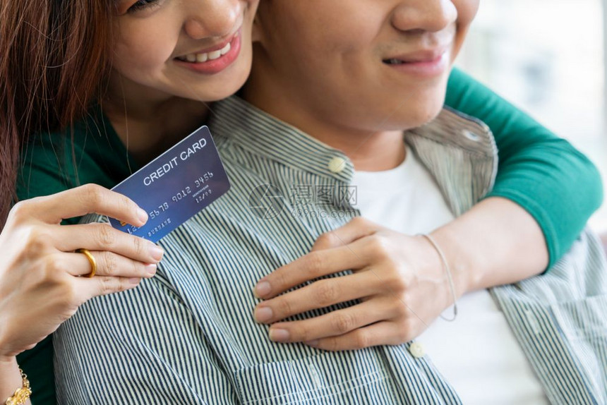 年轻夫妇使用信用卡在家中网购图片