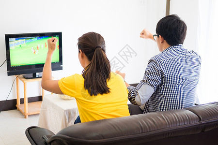 游戏电视在电视上观看足球比赛和欢呼在家里庆祝啤酒和爆米花背景