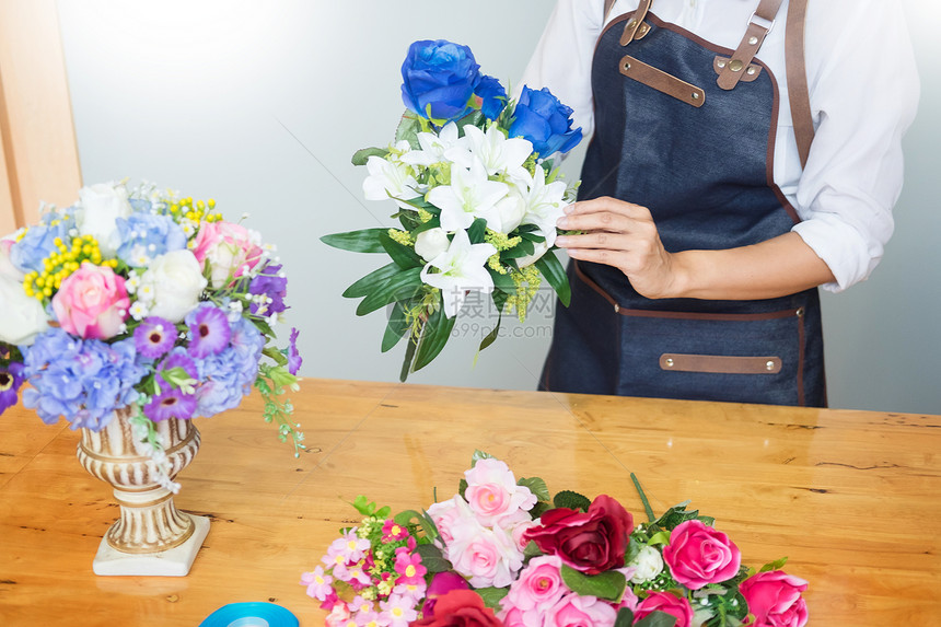 在花店经商销售和花手工艺中通过安排制作美丽的人工花店销售和手工艺的女店和匠图片