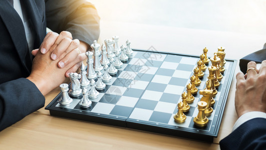 商人在木制桌上玩象棋游戏以分析新战略计划竞争领袖和团队合作成功概念背景图片