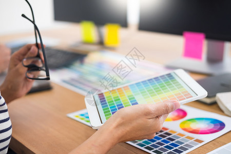 岩彩插画编辑设计师在工作室或办公与计算机一起坐在办公桌前的制图板和彩色调的新项目背景