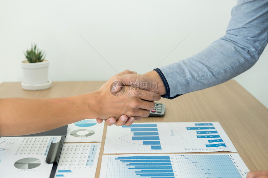 商业在为两家公司签订交易合同后握手图片