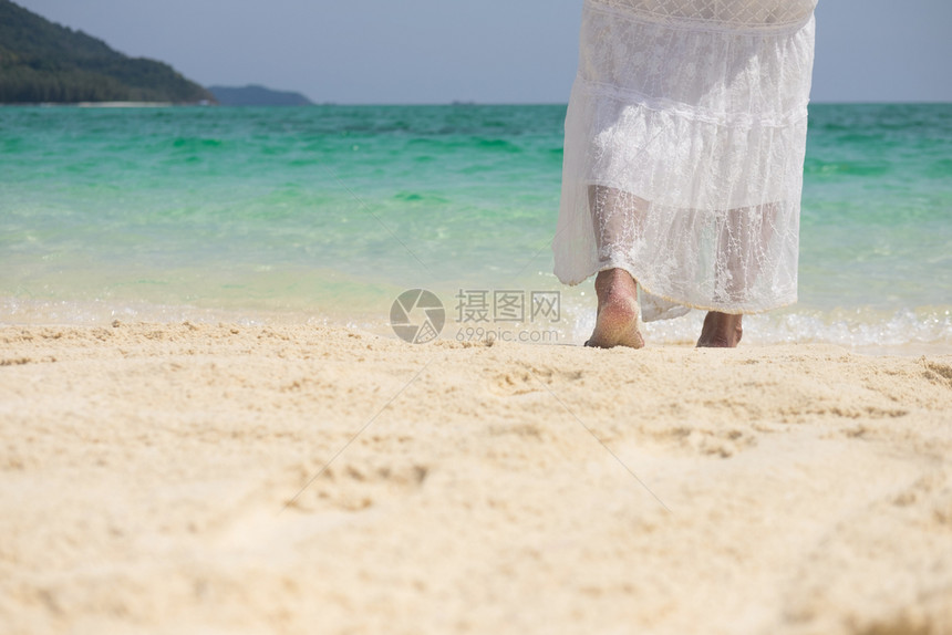 一个美丽的无忧虑女人在海滩上放松享受她的阳光穿着自由服装图片