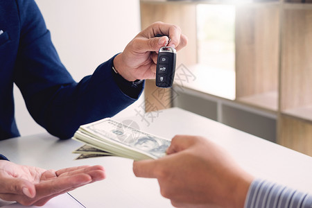 签署汽车保险政策文件和车辆销售协议形式的租赁代理持有单证和汽车钥匙图片