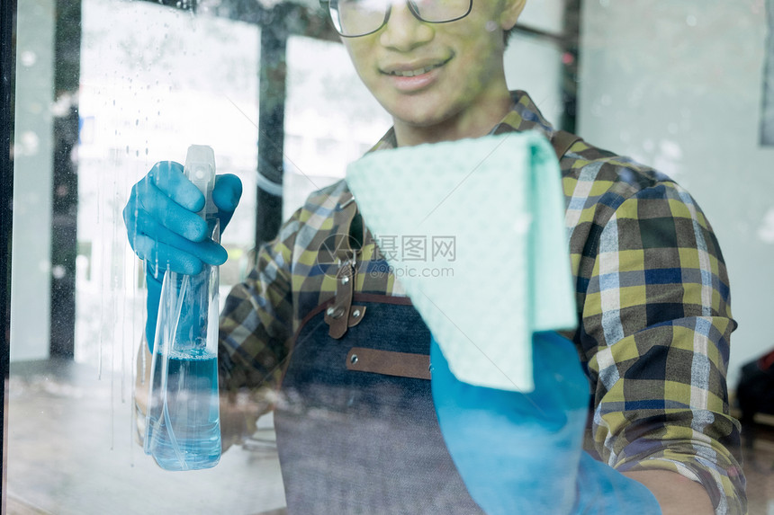 男人用布清洁窗玻璃剂概念图片