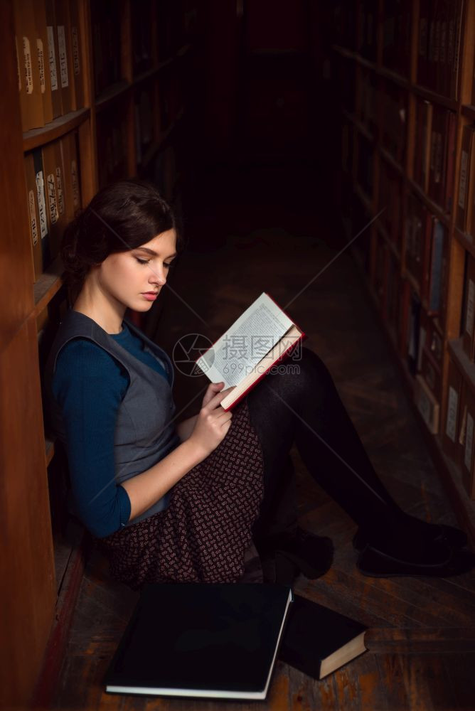 在大学图书馆坐在地上读书的女学生图片