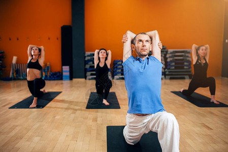 瑜伽训练团体在在室内健身房做瑜伽运动图片